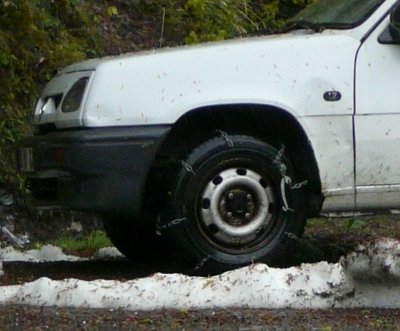 Closeup of snow chains on front wheels of French van